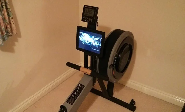 A photograph of the front of a Concept 2 rowing maching, which includes an iPad mounted to the rowers arm.